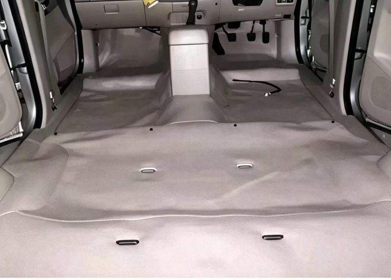 Karpet dasar mobil abu-abu terpasang penuh di lantai kabin